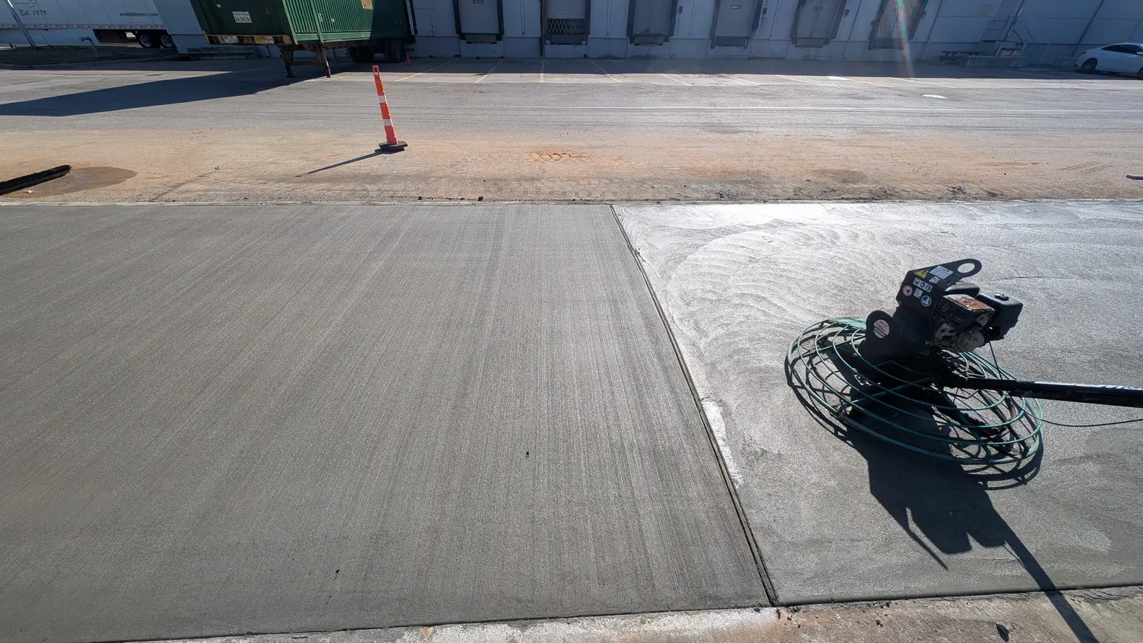 Machine finishing new concrete street paving