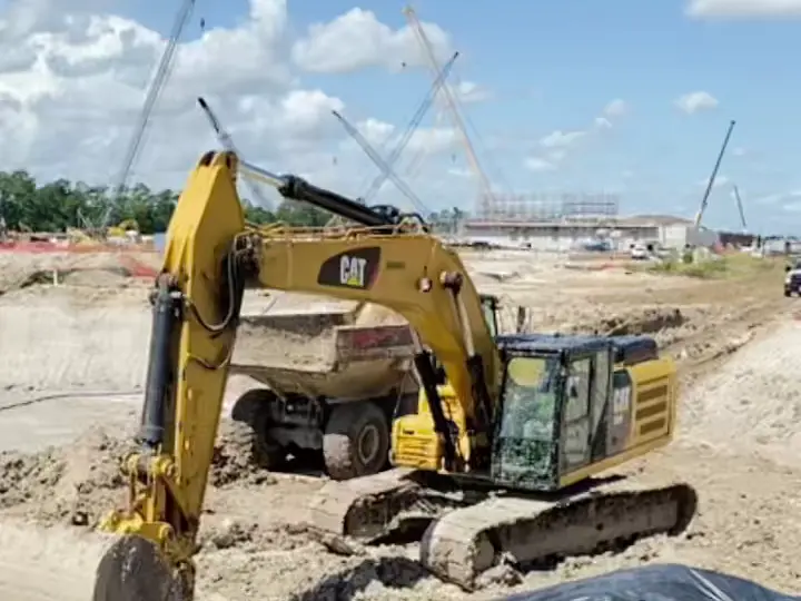 Excavator loading a haul truck with dirt on an active site